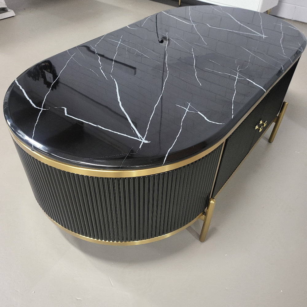 Black marble top coffee table with gold accents on a white floor.