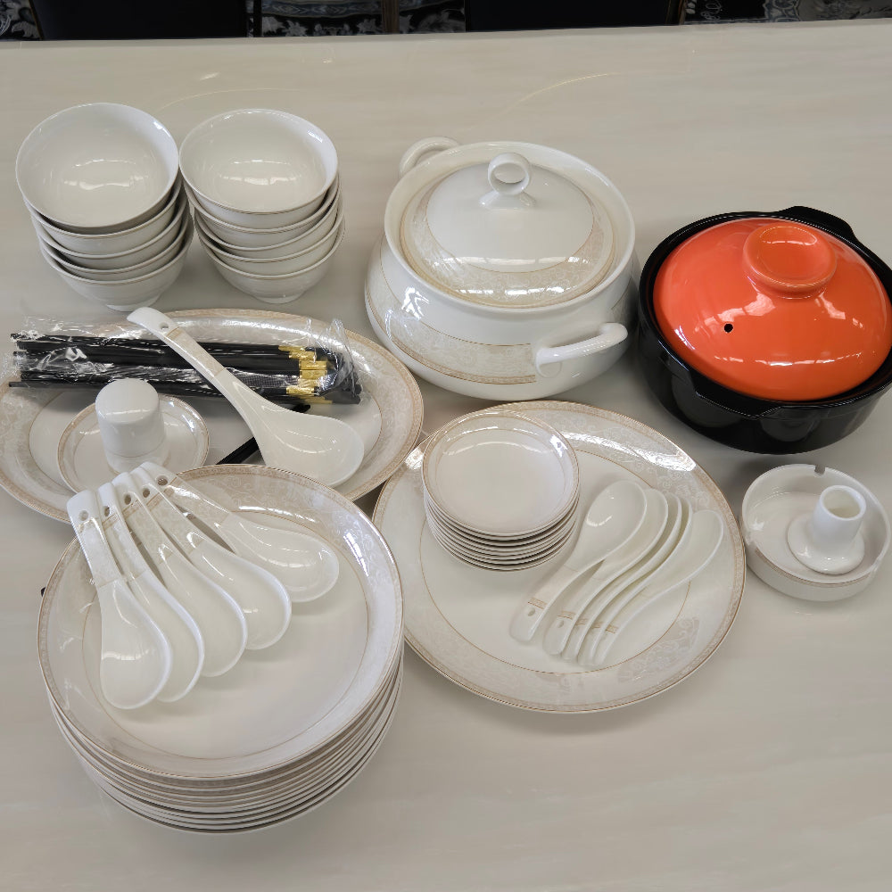 Set of white ceramic dishes including bowls, cups, and spoons on a white surface.