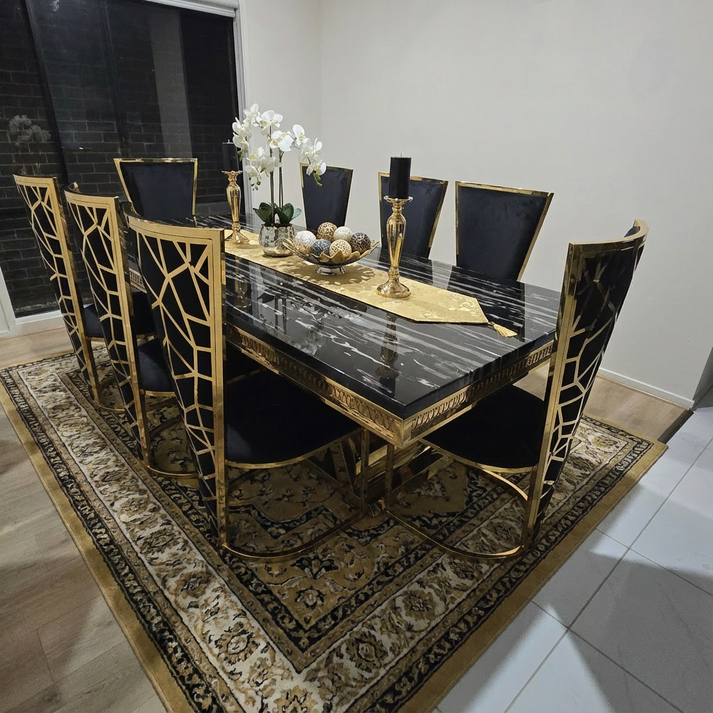 Dining table set with marble top and gold accents in a room with a patterned rug.