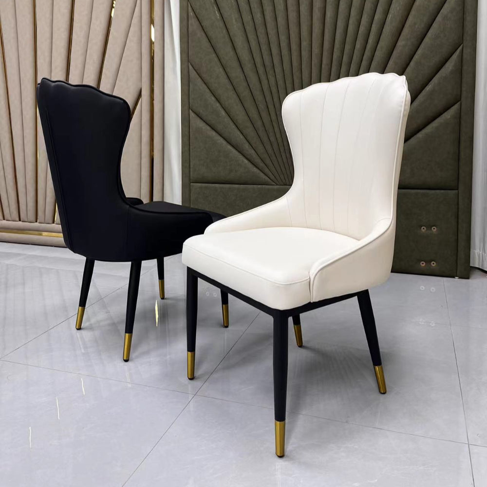 Two chairs, one black and one white, against a decorative wall.