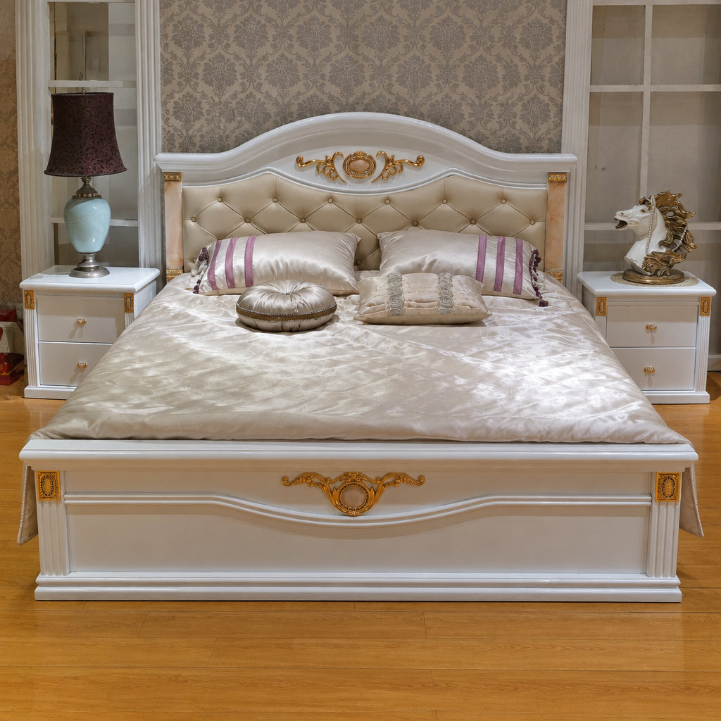 A luxurious bedroom furniture set featuring a king-size bed with a white headboard, two nightstands, a dressing table, and a stool, all with a gold-colored trim and hardware.