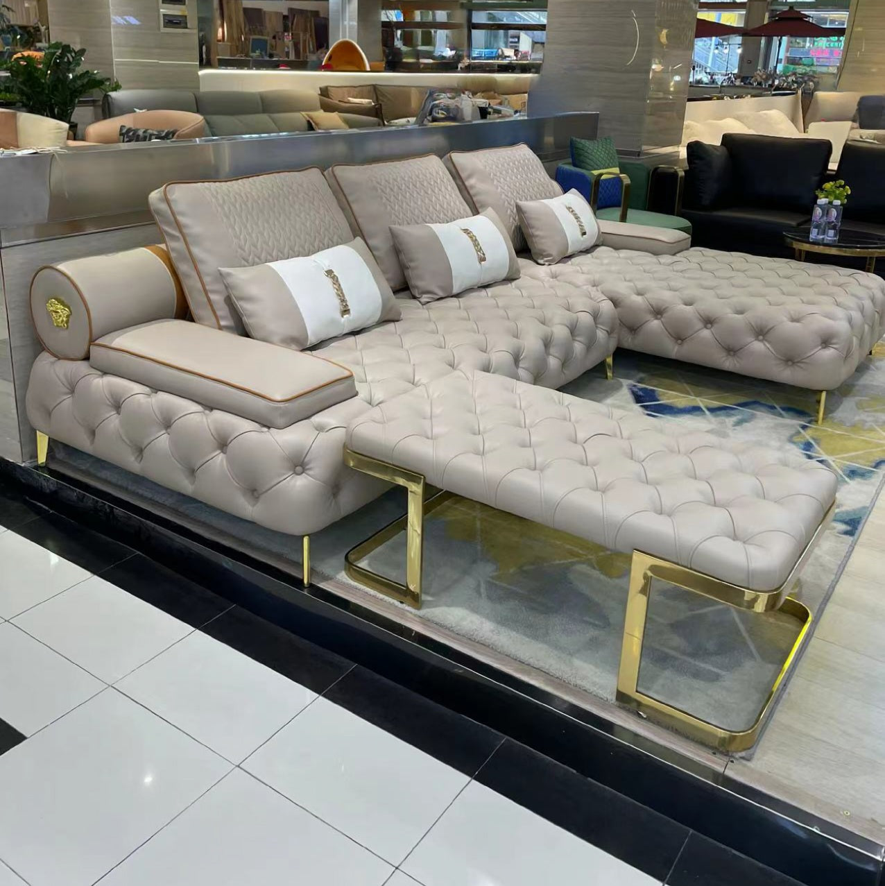 Beige sectional sofa with gold legs in a showroom setting