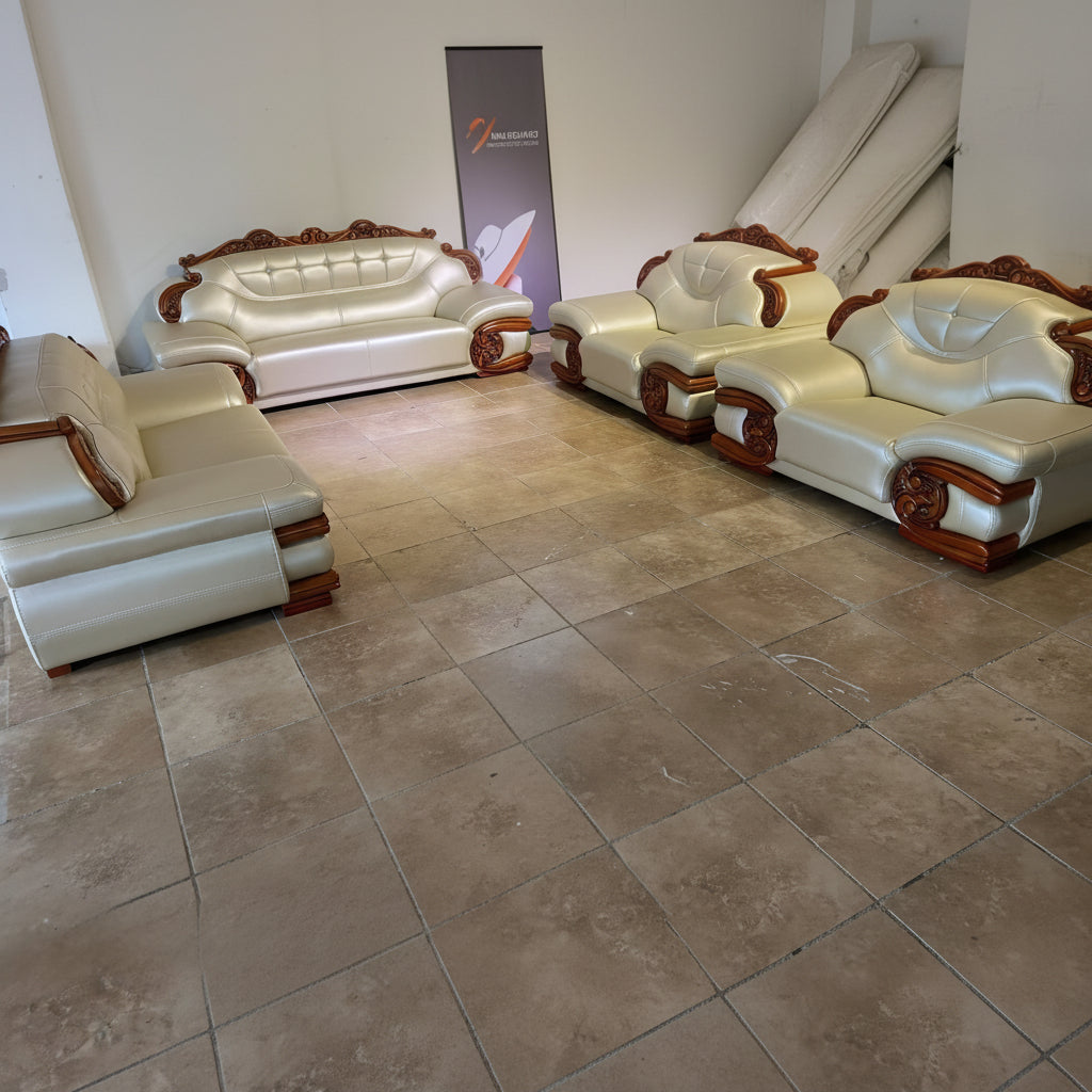 White leather sofa set with wooden accents on a tiled floor.