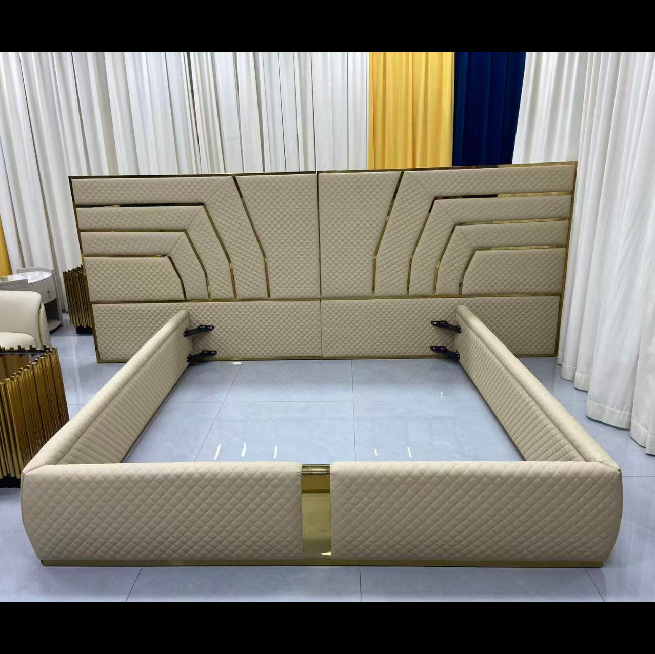 Beige bed frame with decorative headboard in a showroom setting