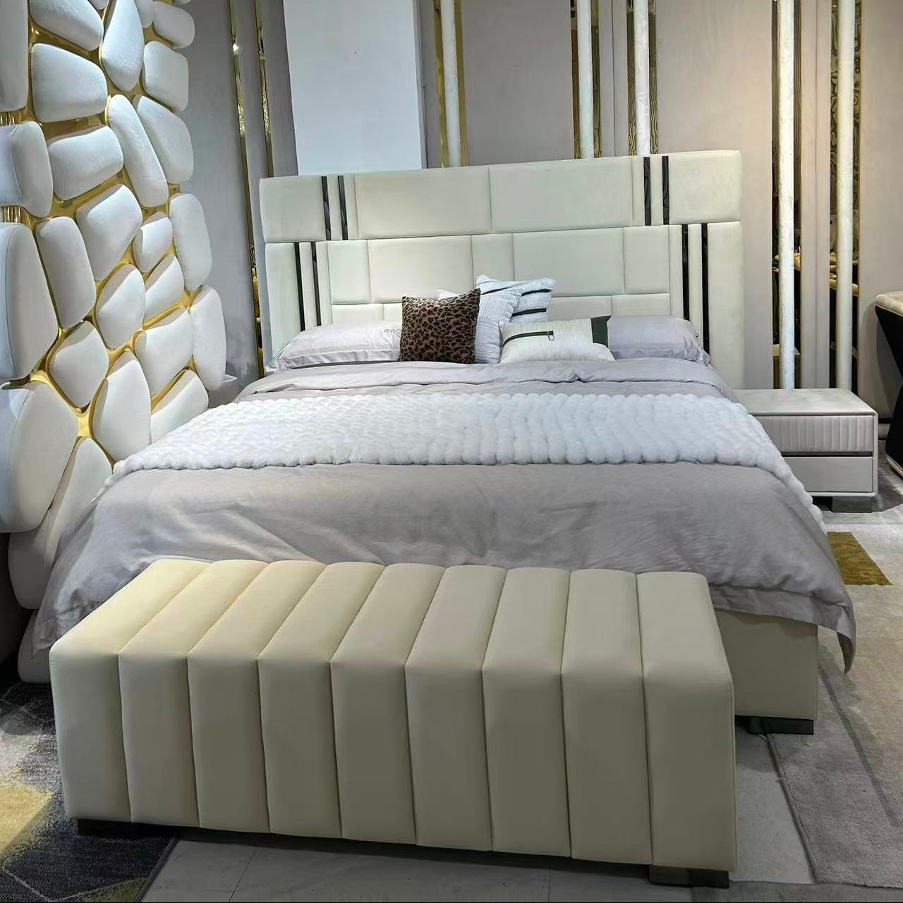 Modern bedroom with a large bed and decorative headboard.