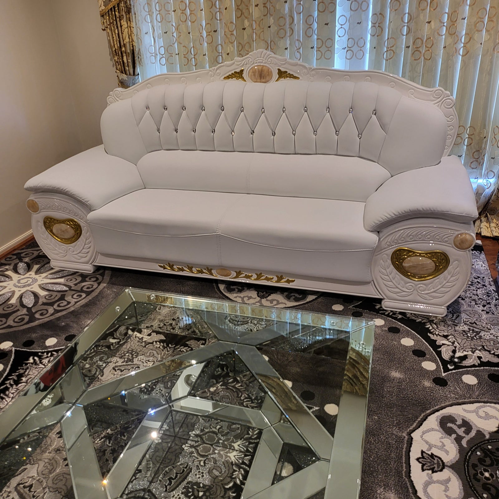 Decorative headboard with intricate designs and gold accents on a patterned rug.
