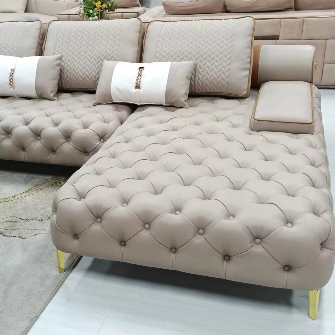 Beige tufted sectional sofa with decorative pillows on a light wood floor.