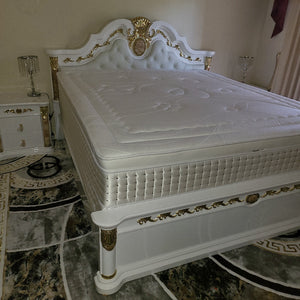White decorative cabinet with gold accents on a marble floor