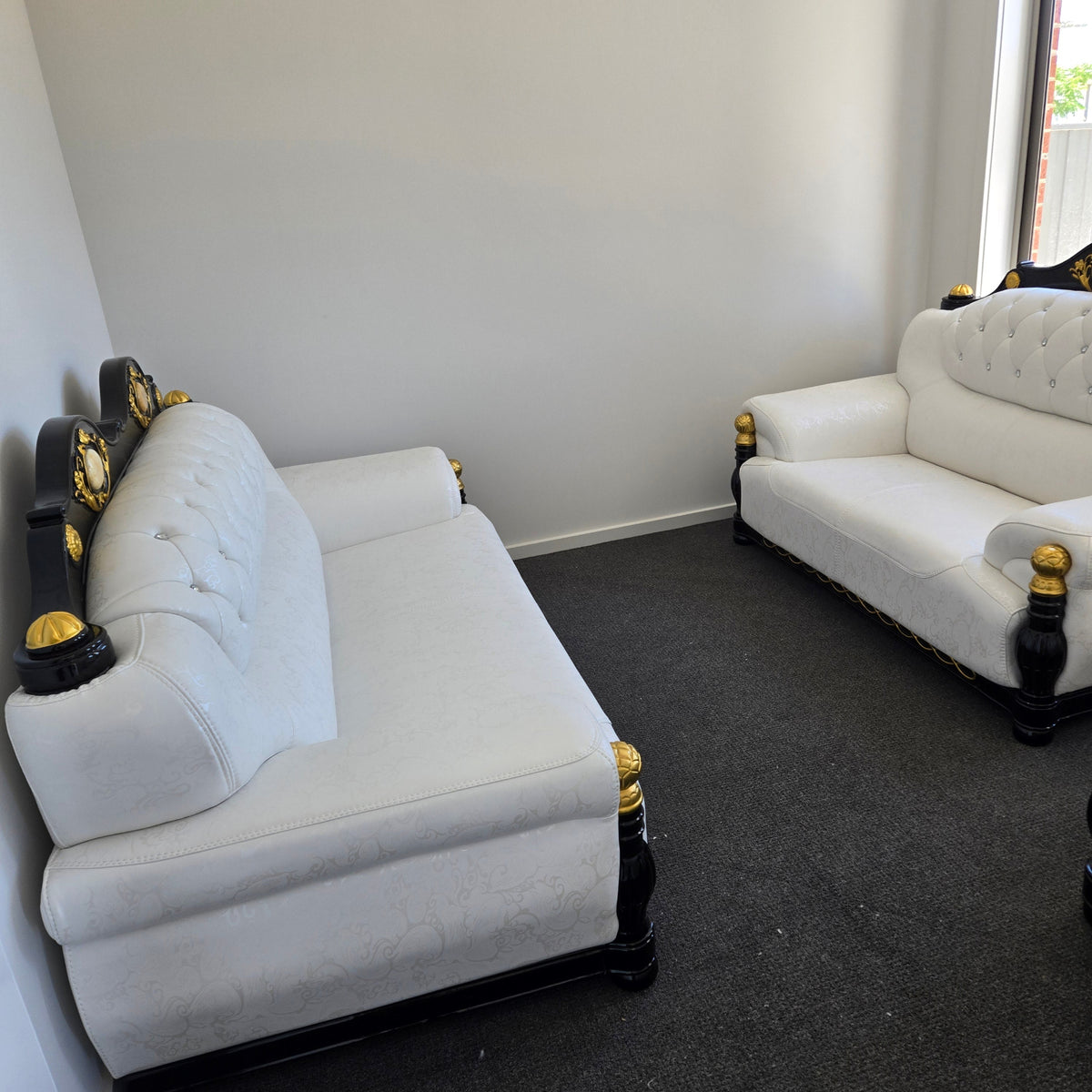 White upholstered car seats with gold accents on a black surface.