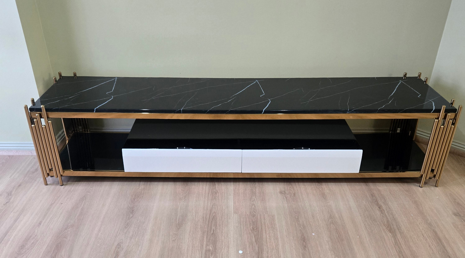 Tall black cabinet with gold frame against a wooden wall.