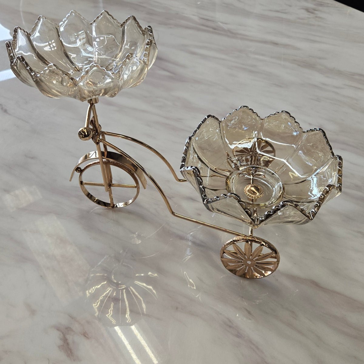 Decorative bicycle shaped serviving piece with floral designs on a marble surface
