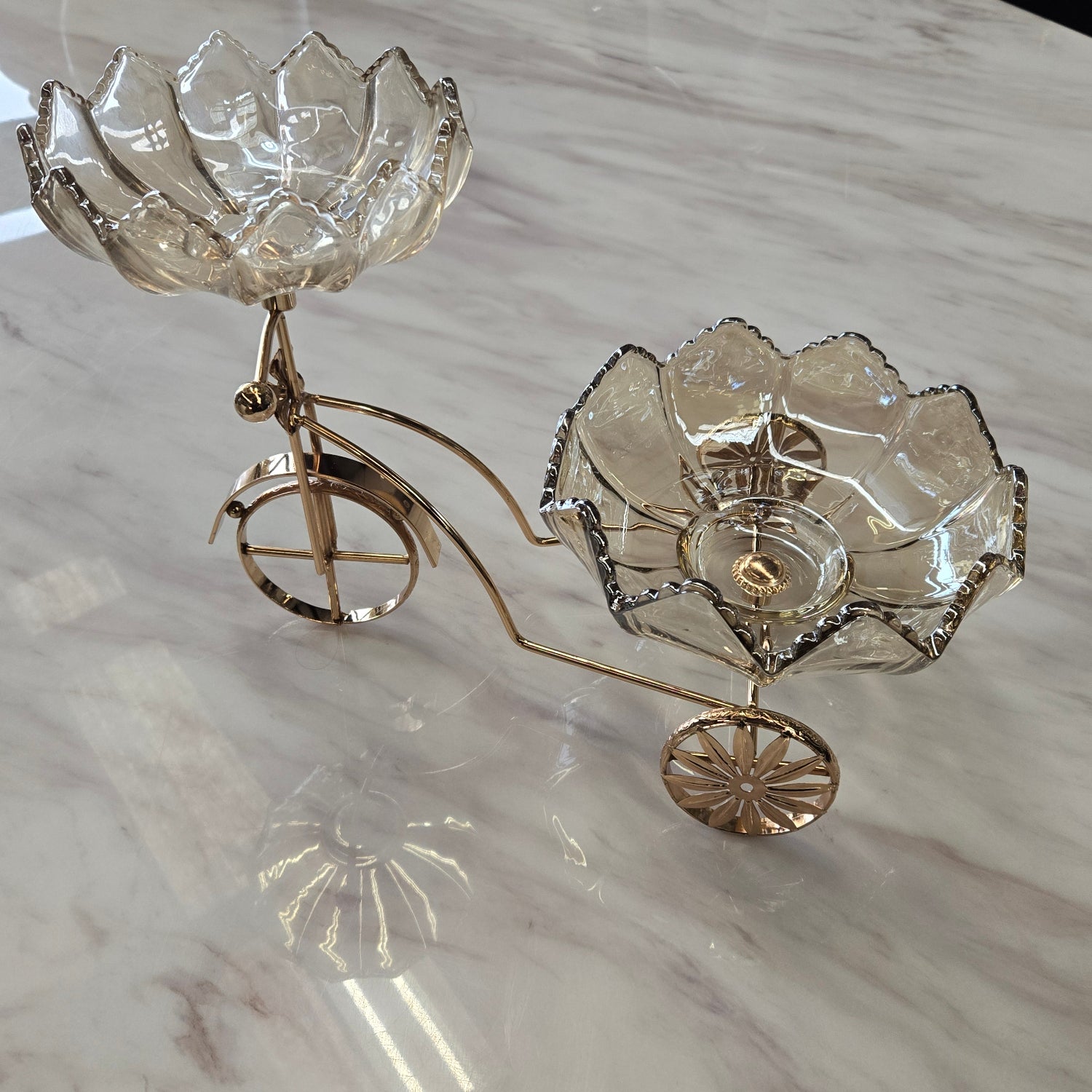 Decorative bicycle shaped serviving piece with floral designs on a marble surface
