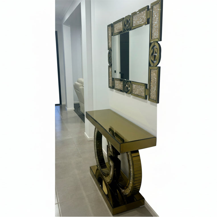 Decorative mirror with intricate frame and console table in a hallway.