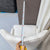 Measuring a white chair with a tape measure in an indoor setting.