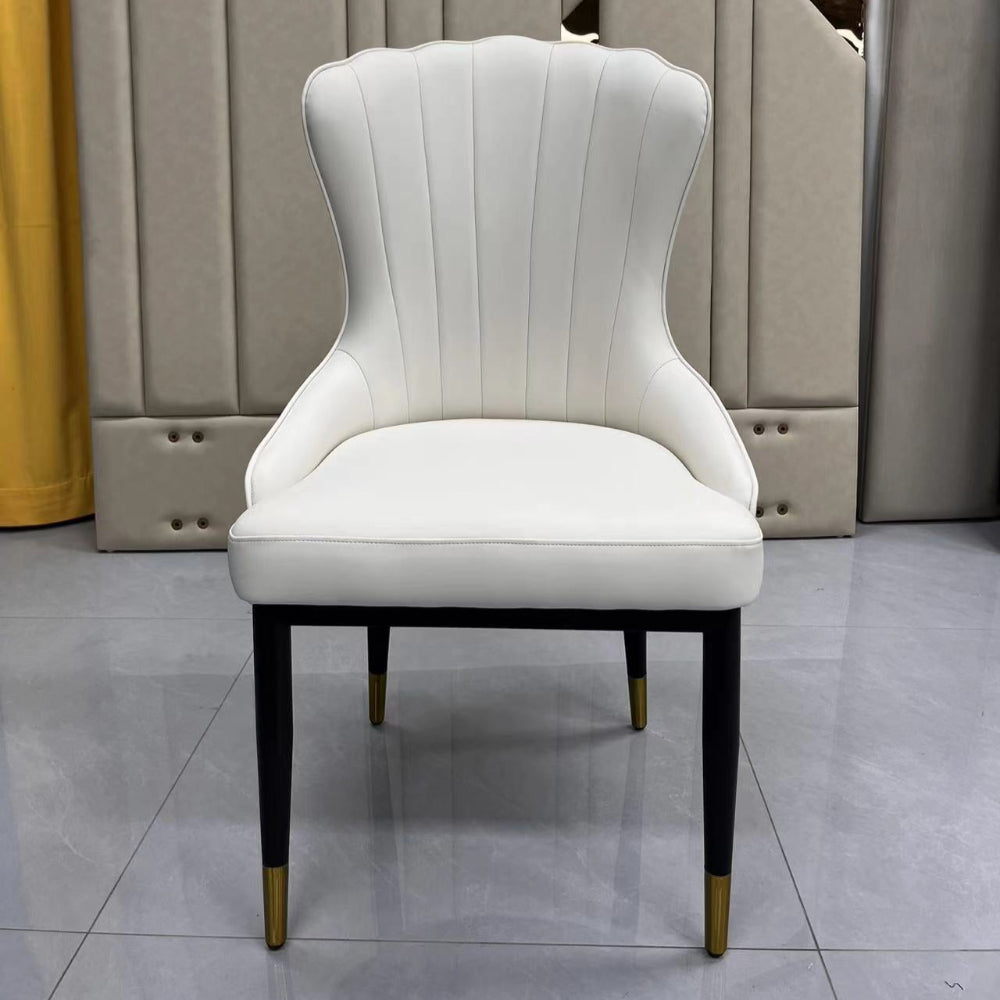 White upholstered chair with black legs against a geometric-patterned wall.