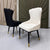 Two chairs, one black and one white, against a decorative wall.