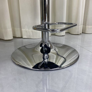 Chrome bar stool on a tiled floor with white curtains in the background