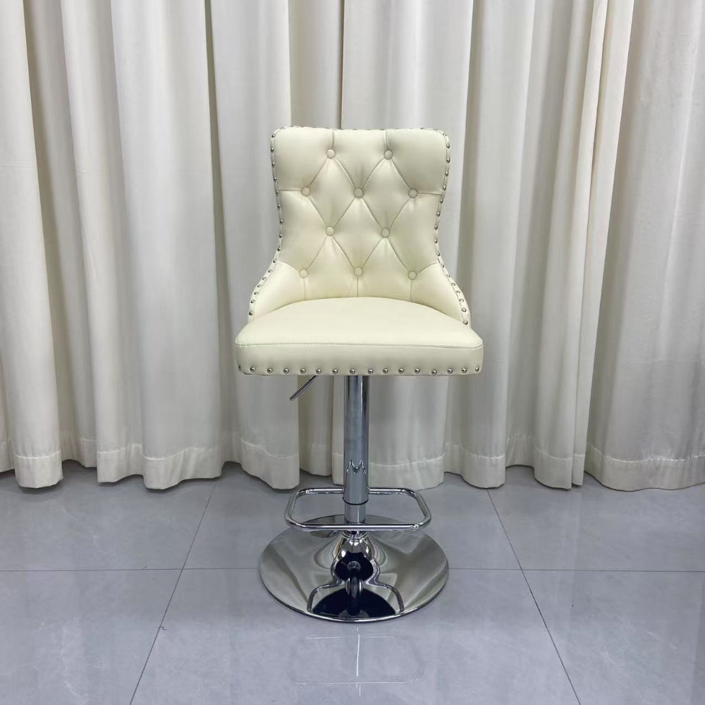 Cream-colored bar stool with a tufted backrest against white curtains.