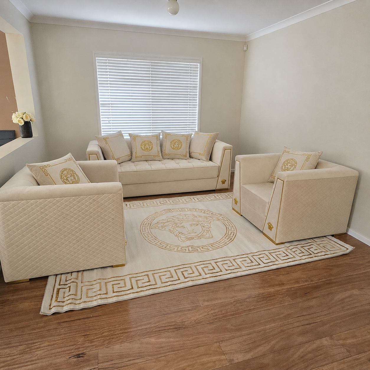 Beige living room furniture set with decorative pillows on a wooden floor.