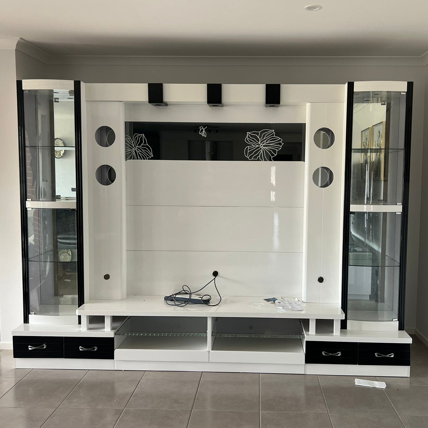 Modern living room with a large entertainment unit and wall-mounted speakers.