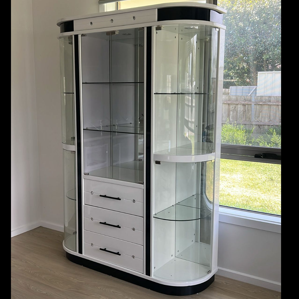 Glass display cabinet with white and black design in a room with a window.