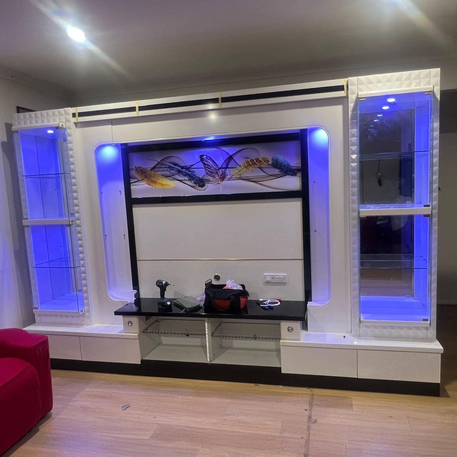 Modern living room with a white entertainment console featuring a TV and decorative items.