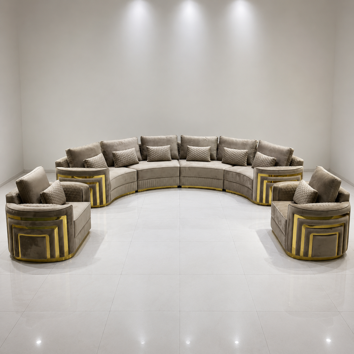 A curved modular upholstered sofa set with two matching armchairs, shown in a bright minimalist showroom. The fabric is a warm taupe-beige with prominent metallic gold geometric frame accents on the base and sides.