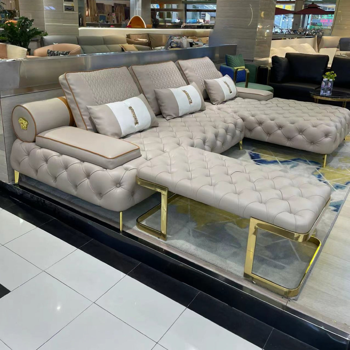 Beige sectional sofa with gold legs in a showroom setting
