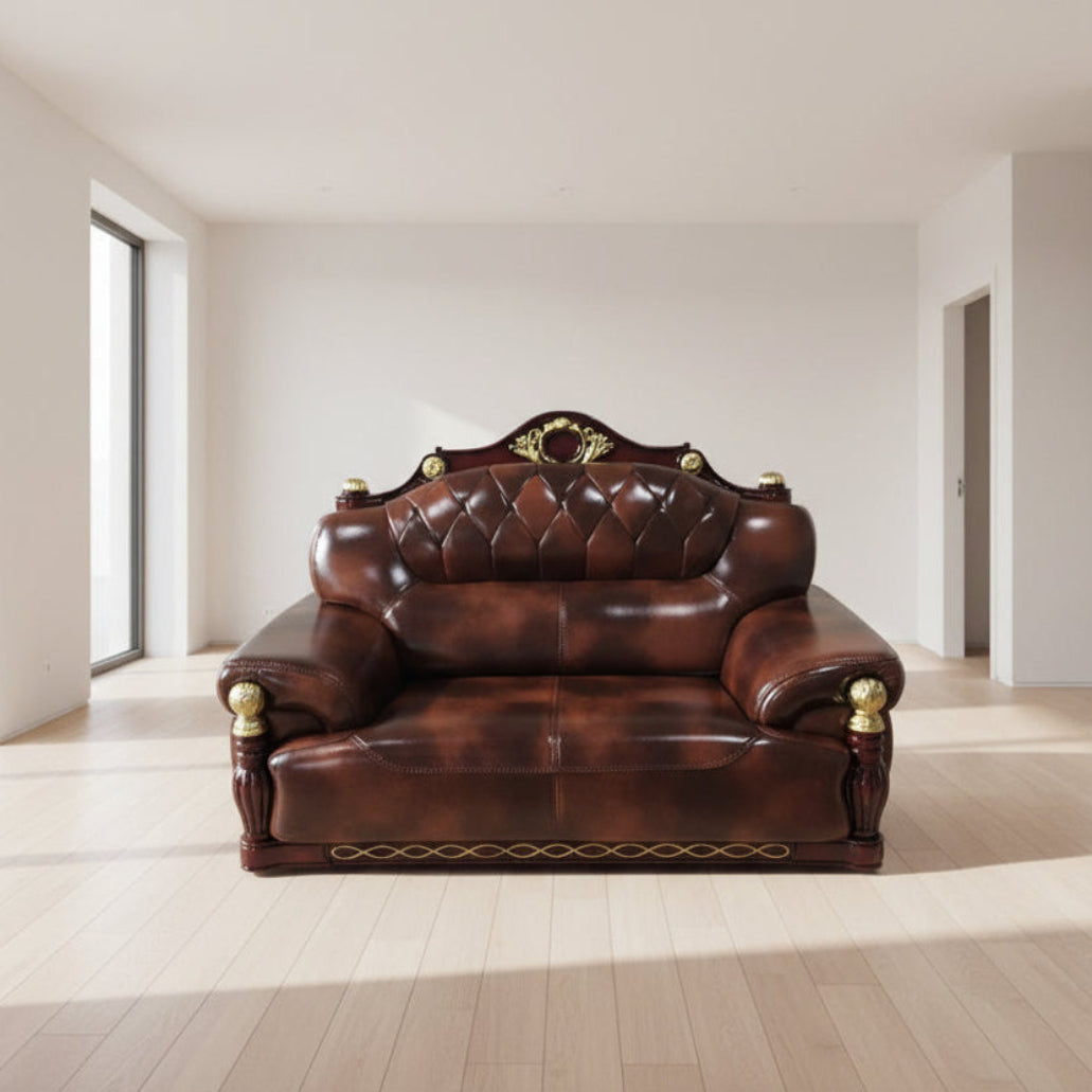 Brown leather sofa with gold accents in a cluttered room.