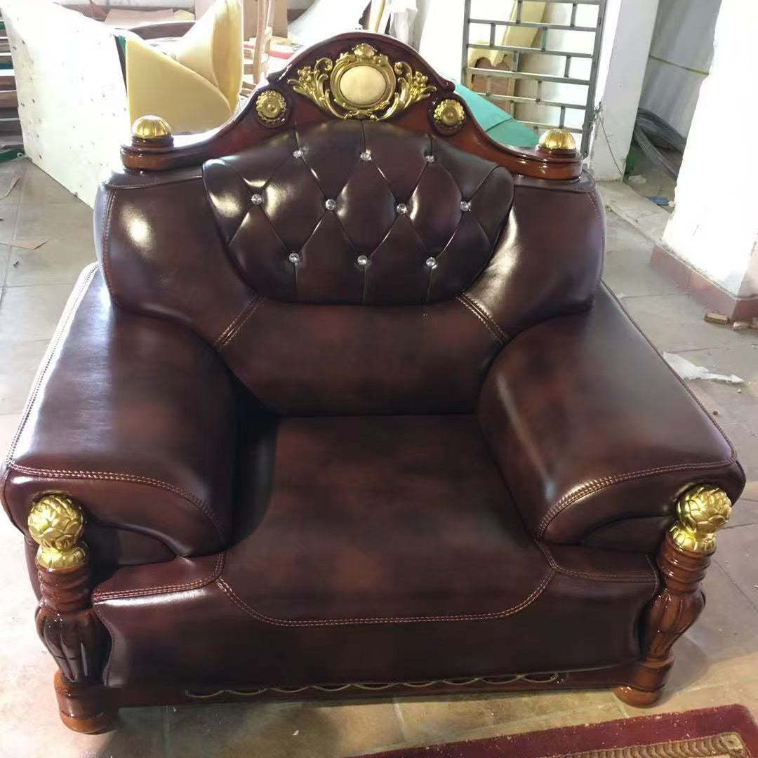 Brown leather armchair with gold accents in a room setting