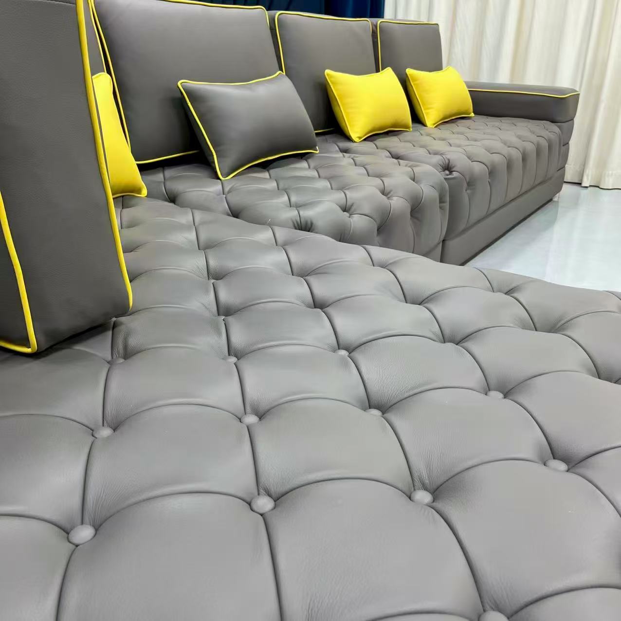 Gray tufted sofa with yellow accents in a living room setting