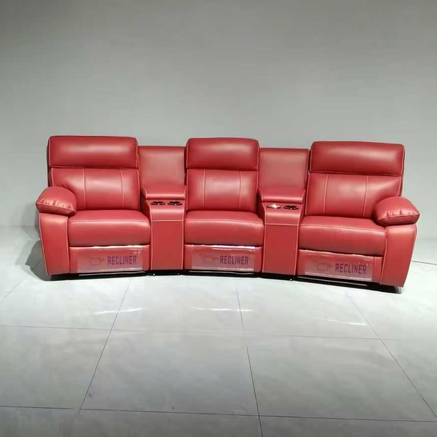 Red recliner sofa on a gray floor with a neutral background