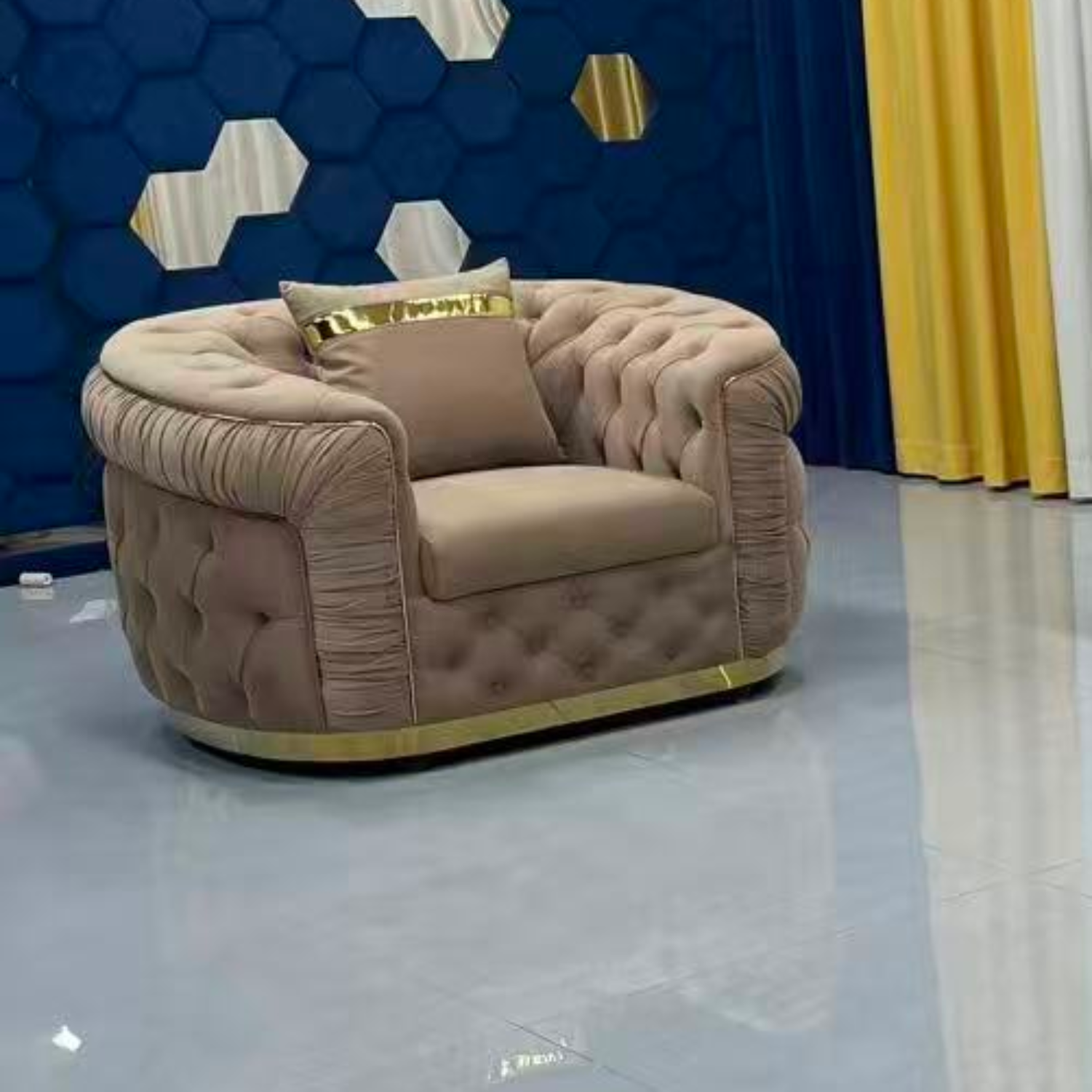 Beige armchair with tufted design in a room with blue and yellow decor