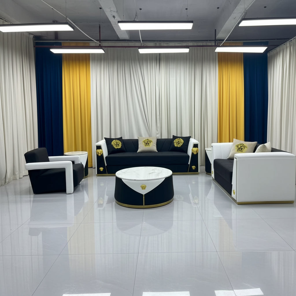 A modern living room furniture set featuring a black and white sofa, matching armchair, round coffee table, and decorative pillows, arranged in a showroom with white and yellow curtains.